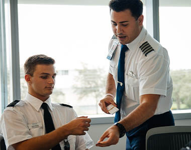 two men in aviation uniforms talking in an conference room
