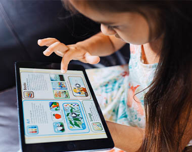 young child using a tablet to learn