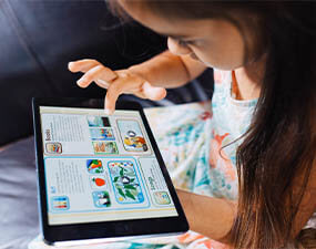 young child using a tablet to learn