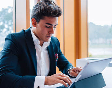 young male professional in a suit working on a tablet