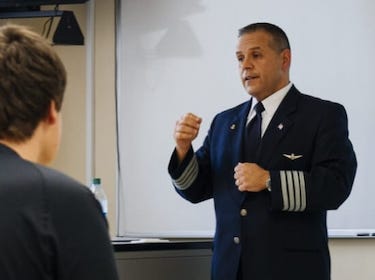 A professor speaks to a group of aviation students