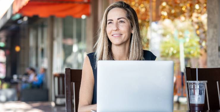 A young teacher writes a classroom management plan on her computer.